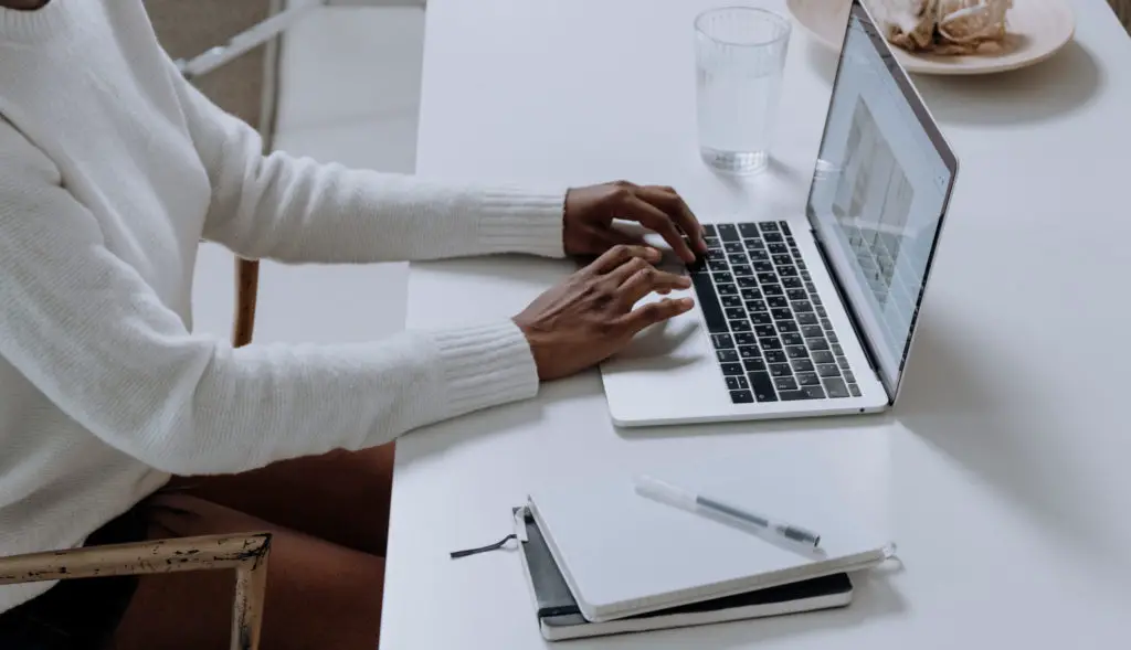 Person in white long sleeve shirt using macbook pro