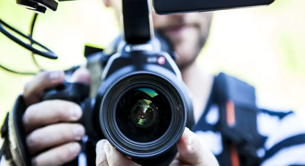 Person holding canon dslr camera close up photo